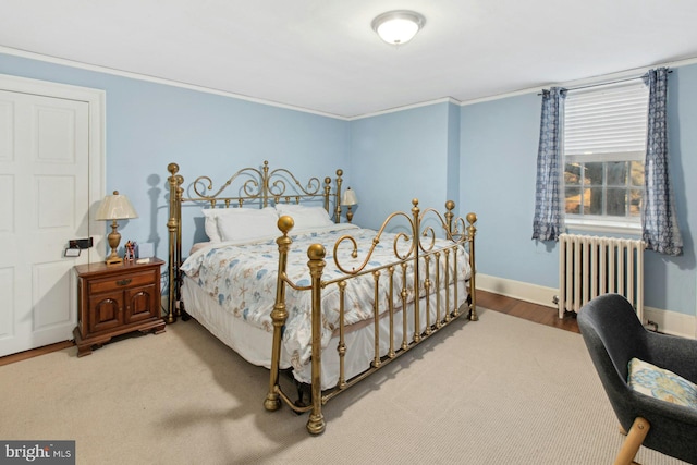 bedroom with hardwood / wood-style flooring, radiator heating unit, and ornamental molding