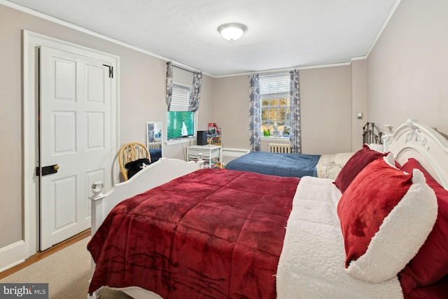 bedroom with crown molding, radiator heating unit, and hardwood / wood-style flooring