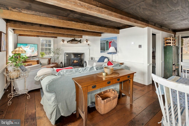 living room with beam ceiling, dark hardwood / wood-style floors, and a wood stove