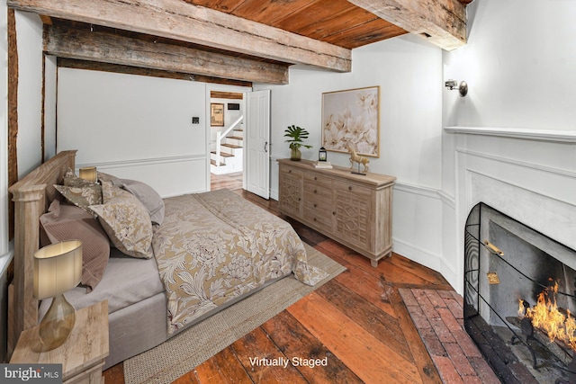 bedroom with wood ceiling, dark hardwood / wood-style floors, and beamed ceiling