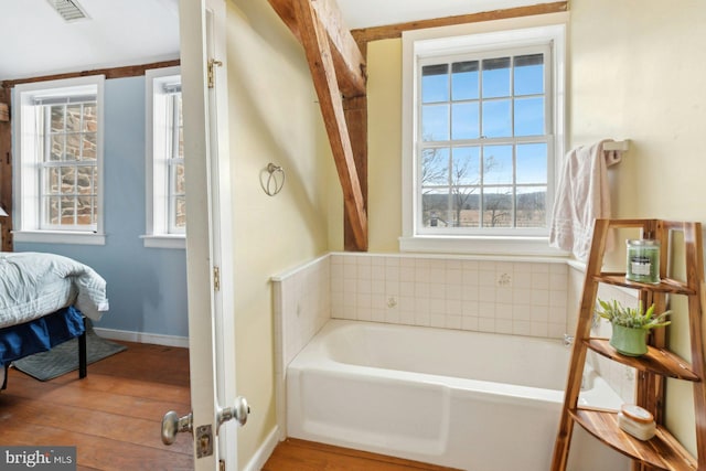 bathroom with wood-type flooring and a bathing tub