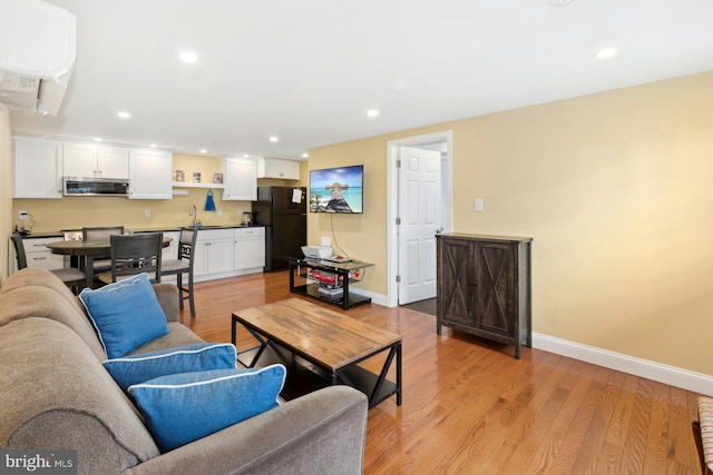 living room with sink and light hardwood / wood-style flooring