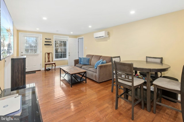 living room with a wall mounted air conditioner and wood-type flooring