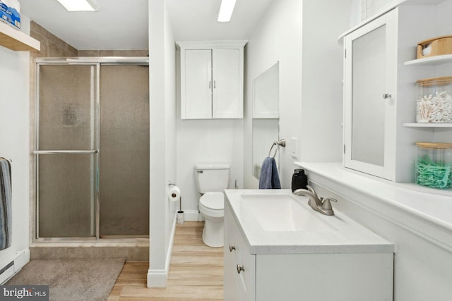 bathroom with hardwood / wood-style flooring, vanity, toilet, and an enclosed shower