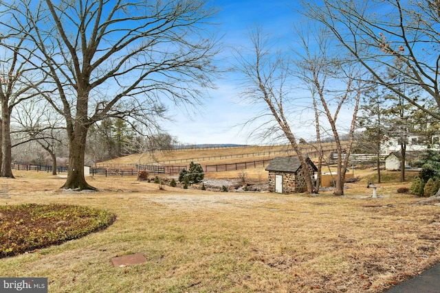 view of yard featuring a rural view and a storage shed