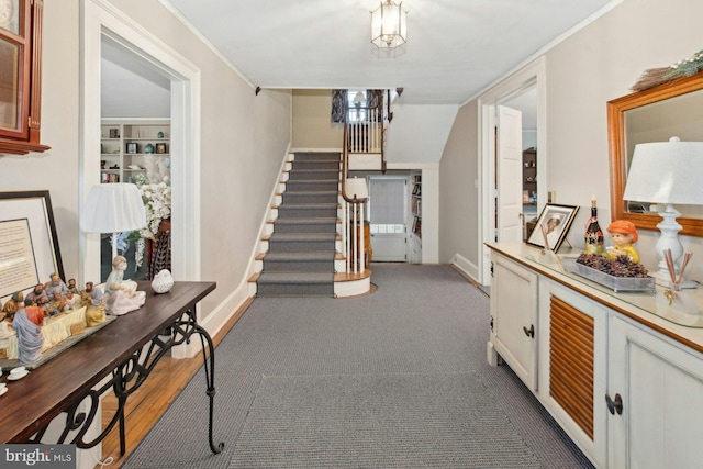 hallway with ornamental molding and built in shelves