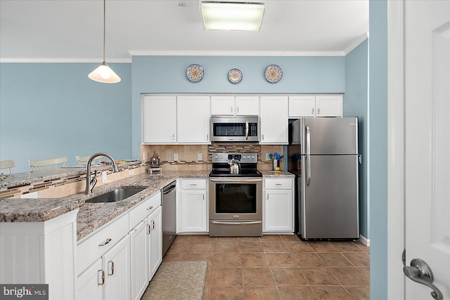 kitchen with a peninsula, a sink, stainless steel appliances, crown molding, and backsplash