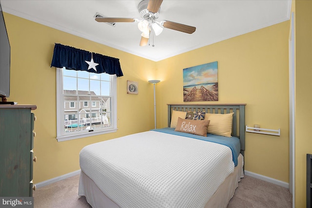 bedroom with baseboards, carpet, ceiling fan, and crown molding