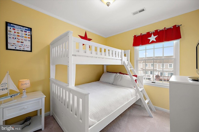 carpeted bedroom featuring crown molding, baseboards, and visible vents