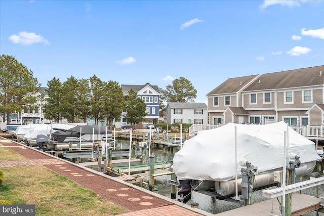 view of dock featuring boat lift, a residential view, and a water view