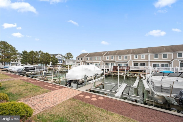 dock area with boat lift, a residential view, and a water view