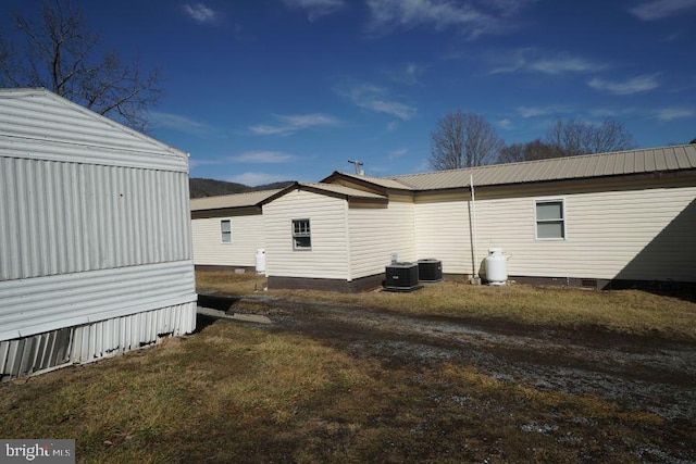 view of side of property featuring a yard and central AC unit