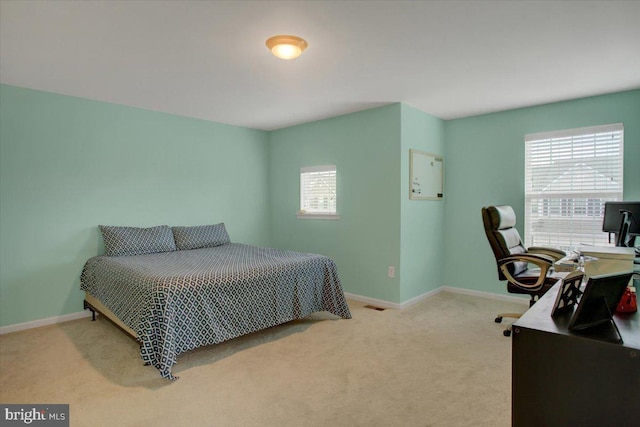 carpeted bedroom featuring visible vents and baseboards