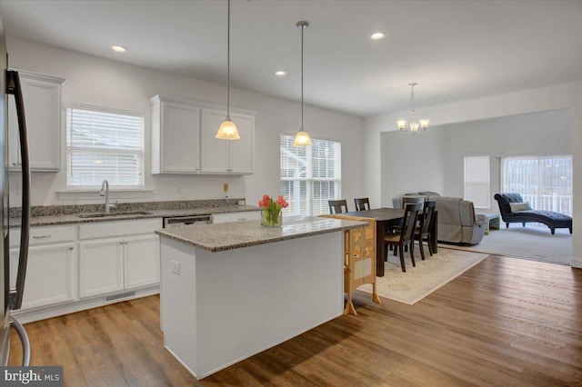 kitchen with white cabinets, a sink, and wood finished floors