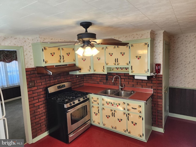 kitchen featuring stainless steel gas stove, sink, and ceiling fan