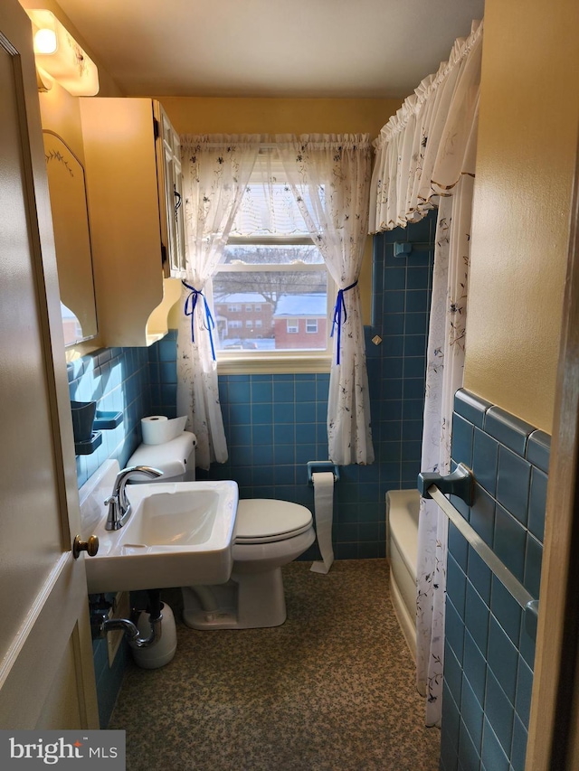 bathroom featuring tile walls, sink, and toilet