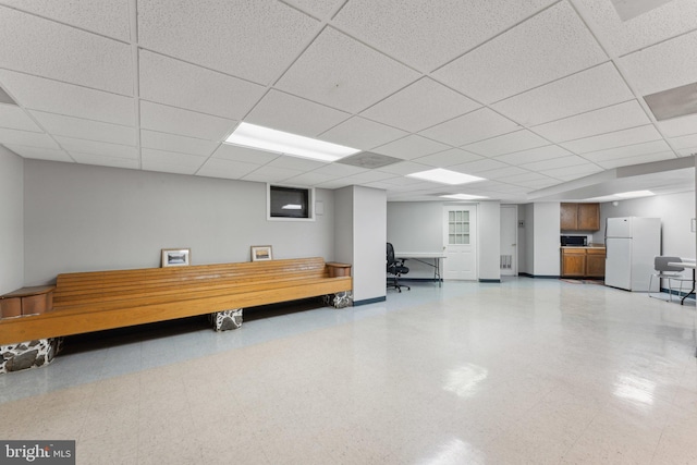 interior space featuring white refrigerator and a drop ceiling