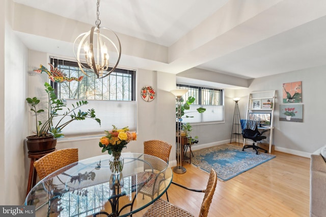 dining area with light wood-type flooring and a chandelier