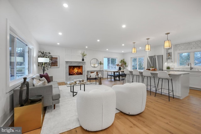 living room with light wood-style floors, a wealth of natural light, and recessed lighting