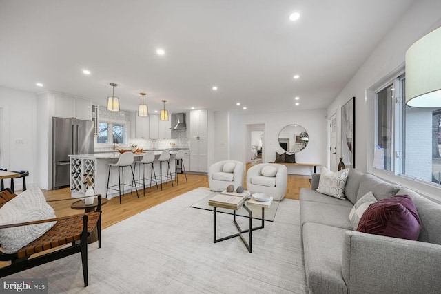 living area with light wood finished floors and recessed lighting