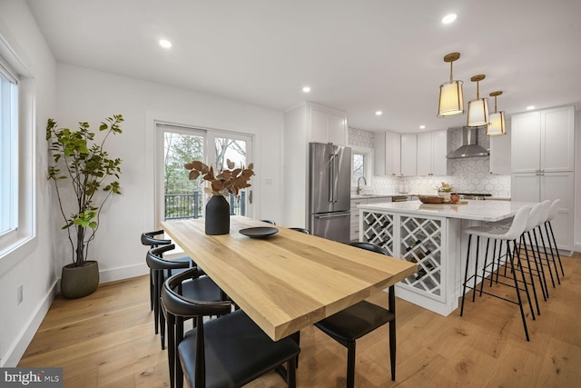 dining area featuring baseboards, light wood-type flooring, and recessed lighting