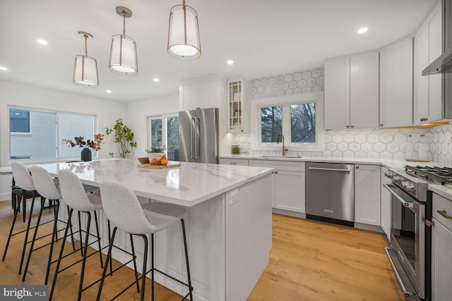 kitchen featuring a sink, pendant lighting, premium appliances, and a center island