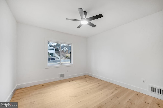 spare room with light wood-style flooring, visible vents, and baseboards