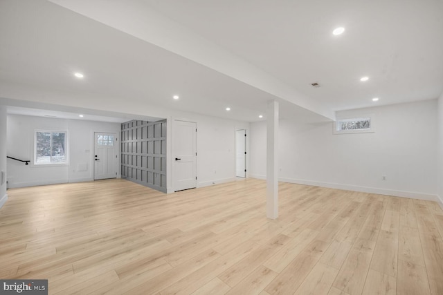 below grade area featuring baseboards, light wood finished floors, and recessed lighting