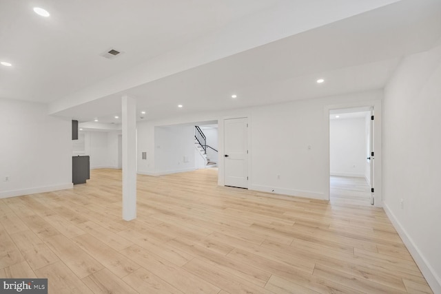 finished basement featuring stairway, recessed lighting, visible vents, and light wood-style flooring