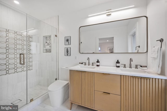 full bath featuring double vanity, a sink, toilet, and a shower stall