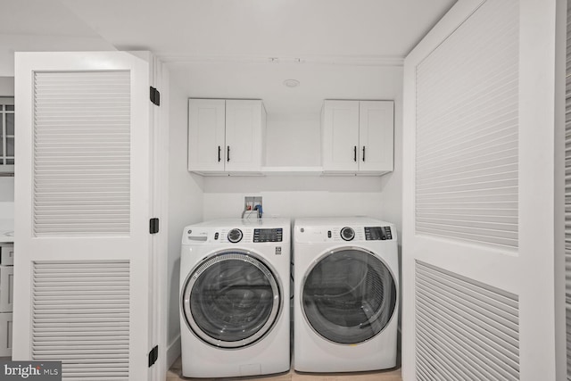 washroom with washing machine and dryer and cabinet space