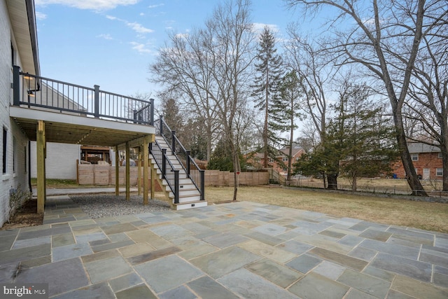 view of patio / terrace with a deck, fence, and stairway