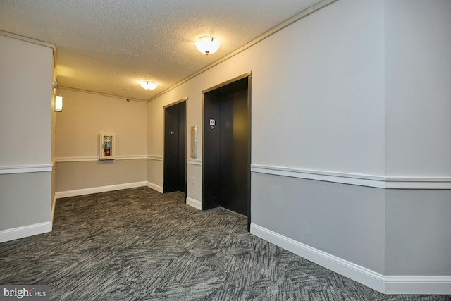 hallway featuring dark carpet, a textured ceiling, and elevator