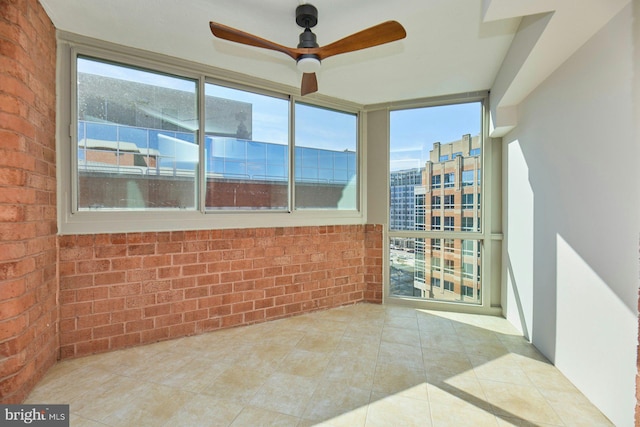 unfurnished sunroom with ceiling fan