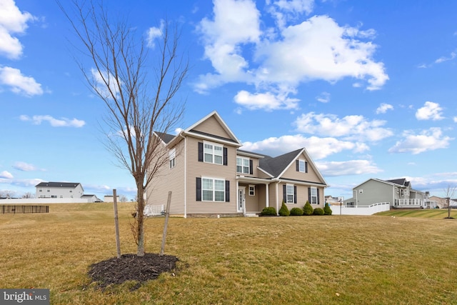 traditional home with a front lawn and fence