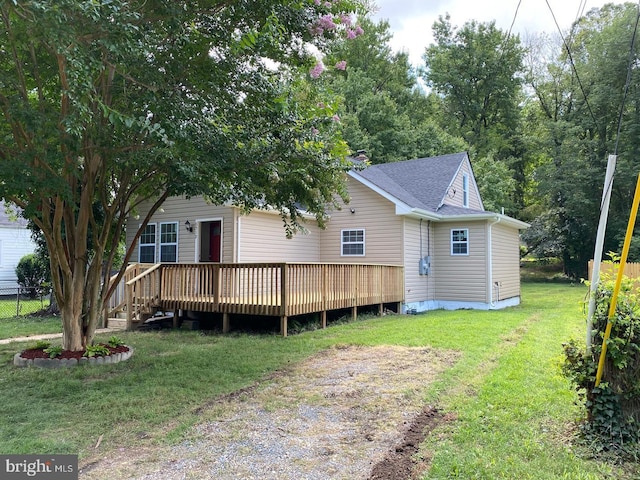 view of front of property featuring a deck, fence, crawl space, roof with shingles, and a front lawn