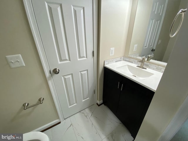 bathroom with marble finish floor, tasteful backsplash, baseboards, and vanity