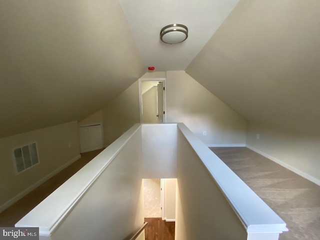 staircase with lofted ceiling, baseboards, and visible vents