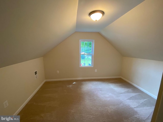 additional living space featuring vaulted ceiling, carpet, visible vents, and baseboards