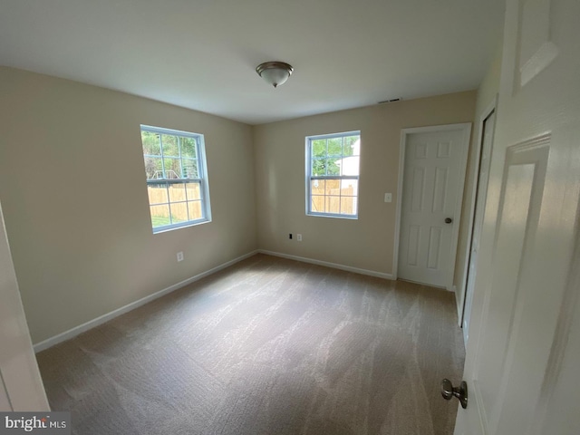 unfurnished bedroom featuring light carpet, visible vents, and baseboards