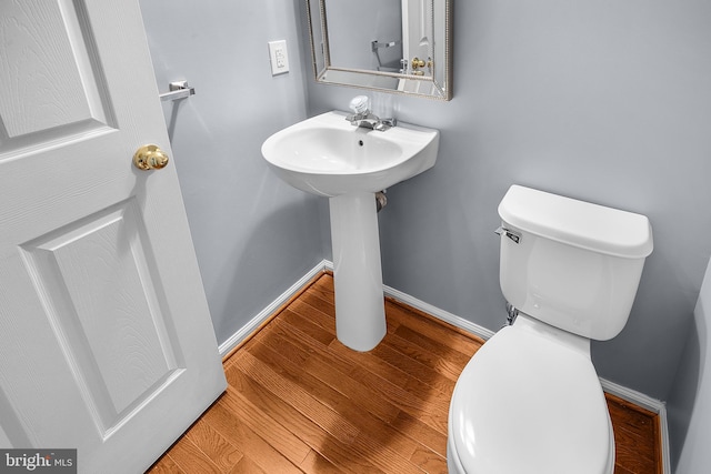 bathroom featuring hardwood / wood-style flooring and toilet