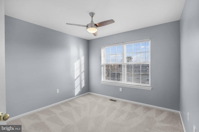 carpeted spare room with ceiling fan