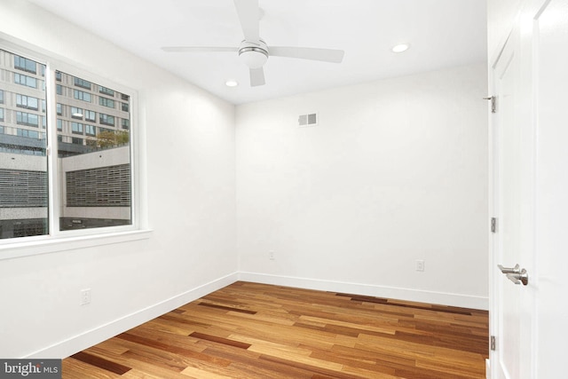 unfurnished room featuring baseboards, visible vents, ceiling fan, wood finished floors, and recessed lighting