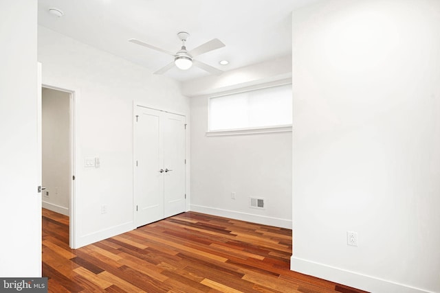 unfurnished bedroom with visible vents, ceiling fan, baseboards, and wood finished floors