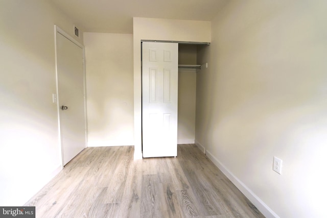 unfurnished bedroom featuring a closet and light wood-type flooring