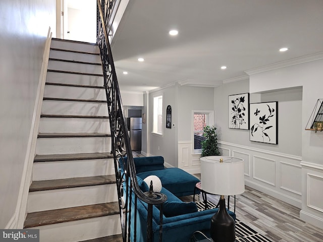 staircase featuring ornamental molding and wood-type flooring