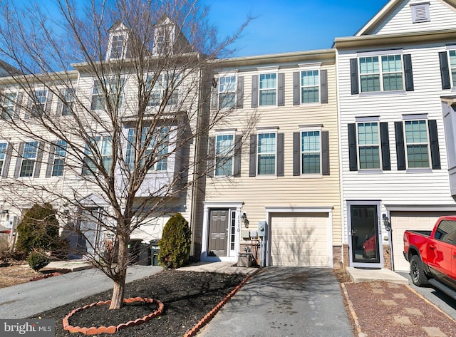 multi unit property featuring a garage and driveway