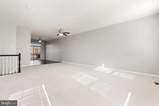 carpeted spare room featuring baseboards