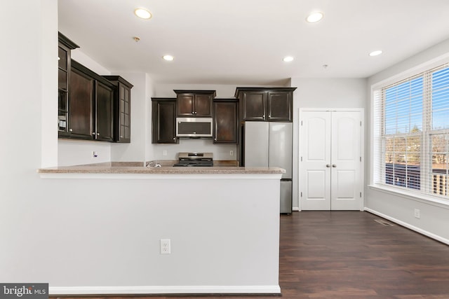 kitchen featuring appliances with stainless steel finishes, light countertops, and dark brown cabinetry