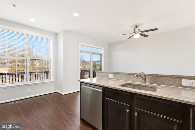 kitchen with dark wood-style floors, a sink, stainless steel dishwasher, and light stone countertops